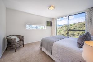 1 dormitorio con cama y ventana grande en Million Dollar View - Takamatua Holiday Home, en Akaroa