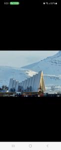 dos fotografías de un gran edificio con una pirámide en Apartment By The Lakeside, en Tromsø