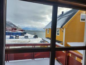 una vista desde una ventana de una casa en la nieve en Apartment By The Lakeside, en Tromsø