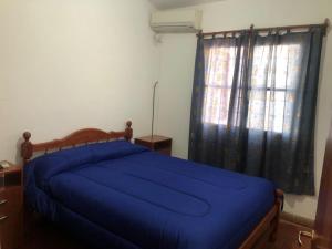 a bedroom with a blue bed and a window at La escondida in Salta