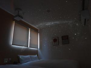 ein Schlafzimmer mit einem Bett und ein Fenster mit Sternen an der Wand in der Unterkunft Rakuten STAY VILLA Yatsugatake - 107 Simple Modern - in Hokuto