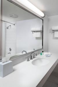 a bathroom with a sink and a large mirror at Four Points by Sheraton Bakersfield in Bakersfield
