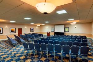 a conference room with blue chairs and a podium at Four Points by Sheraton Bakersfield in Bakersfield