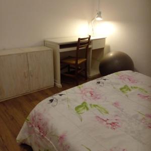 a bedroom with a desk and a bed with a bedspread with flowers at Departamento en Tigre centro in Tigre