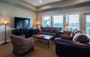 uma sala de estar com um sofá e uma televisão em Sunrise Valley Suite em West Kelowna