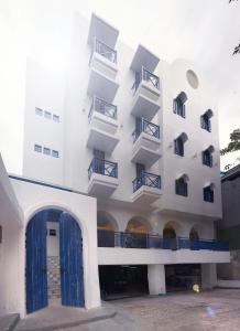 a white building with balconies and a blue door at Little Mykonos in Bandung