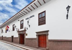 un edificio bianco con porte rosse su una strada di Terra Andina Colonial Mansion a Cuzco