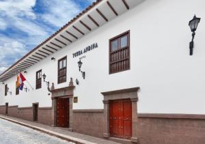 a white building with red doors on a street at Terra Andina Colonial Mansion in Cusco