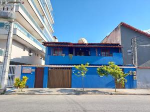 un edificio azul al lado de una calle en Pousada Melodia do Mar en Cabo Frío