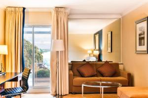 a living room with a couch and a large window at Sheraton Skyline Hotel London Heathrow in Hillingdon