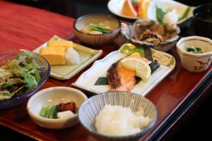 a table topped with plates of food and bowls of food at Yakushidaira Akanejyuku in Matsumoto