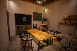 a dining room with a table and chairs and a chalkboard at Sunny Homestay&One House in Zhangjiajie
