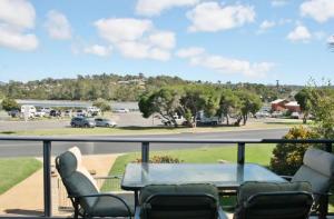 einen Balkon mit einem Tisch und Stühlen sowie einen Parkplatz in der Unterkunft 526 Arthur Kaine Dr Merimbula in Merimbula