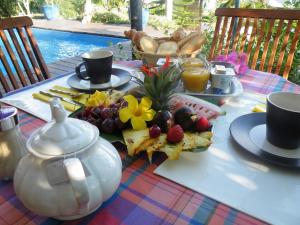 einen Tisch mit einem Teller Essen und einer Teekanne in der Unterkunft La Villa Zen in Saint-Paul
