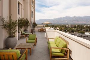 Un balcón con sillas y mesas en un edificio en The Westin Pasadena, en Pasadena