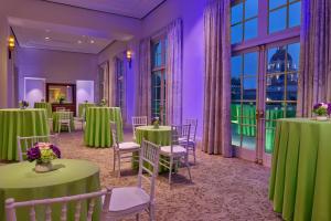 a ballroom with green tables and chairs and windows at The Westin Pasadena in Pasadena