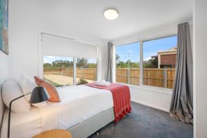 a bedroom with a bed and a large window at Mandalay Beach House on Pipe Clay Lagoon in Sandford +31 photos
