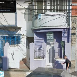 a man walking in front of a blue building at Santa Alexandrina in Rio de Janeiro