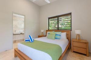 a bedroom with a bed and two windows at Villa On The Hill - Spacious Tropical Panorama in Port Douglas