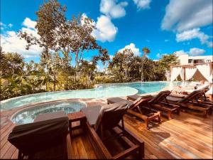 a deck with chairs and a swimming pool at New Suite Deluxe Tulum Ophelia Community Living in Tulum