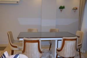 كومبوند زايد ديونز في Sheikh Zayed: طاولة غرفة طعام مع أربعة كراسي حولها