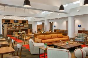 a lobby with a couch and tables and a bar at Four Points by Sheraton Dallas Fort Worth Airport North in Coppell