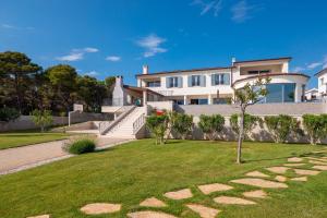 a large white house with a grass yard at Villa Luxury Maja Zablace in Šibenik