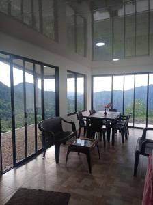 - une salle à manger avec une table, des chaises et des fenêtres dans l'établissement Casa de campo en La Vega, hermosa vista, con Internet y parqueadero, à La Vega