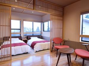 Akakura的住宿－Ryokan Okayama，一间卧室配有两张床和一张桌子及椅子