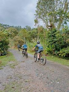 three people riding bikes down a dirt road at Casa de campo en La Vega, hermosa vista, con Internet y parqueadero in La Vega +62 photos