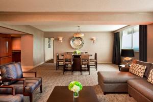 a living room with a couch and a dining room at Sheraton Greensboro in Greensboro