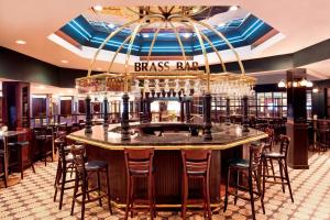 a bar in a restaurant with a bar counter at Sheraton Greensboro in Greensboro