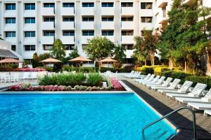 a hotel swimming pool with white chairs and a building at Sheraton Greensboro in Greensboro