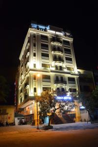 a large white building with lights on it at night at Osaka Ha Long Hotel in Ha Long