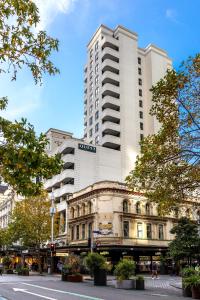 a tall white building in the middle of a street at Quest on Queen Serviced Apartments in Auckland