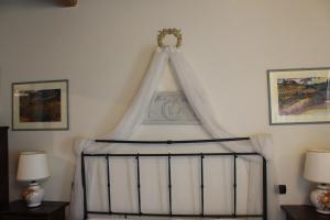 a bed with a canopy in a room with two lamps at Locanda La Mandragola in San Gimignano