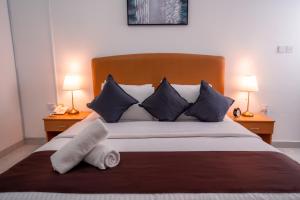 een slaapkamer met een groot bed met blauwe en witte kussens bij العاصمة للشقق الفندقية - Capital Hotel Apartments in Muscat