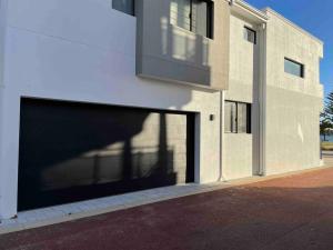 a building with a large garage door on the side of it at New ground floor 2 bed/2 bath Apartment Marina in Mandurah