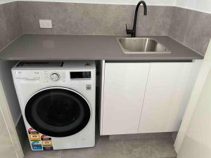 a kitchen with a washing machine and a sink at New ground floor 2 bed/2 bath Apartment Marina in Mandurah