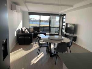 a living room with a table and a couch at New ground floor 2 bed/2 bath Apartment Marina in Mandurah
