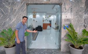 een man in een kantoor met zijn arm uit bij العاصمة للشقق الفندقية - Capital Hotel Apartments in Muscat