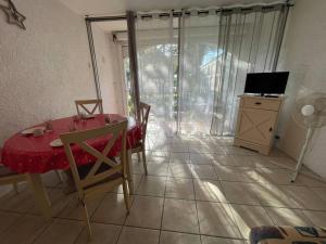 een eetkamer met een rode tafel en stoelen en een televisie bij Appartement Argelès-sur-Mer, 1 pièce, 4 personnes - FR-1-225-782 in Argelès-sur-Mer