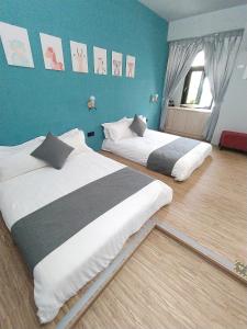 2 camas en una habitación con paredes azules en 二街館-光影民宿Light Shadow - Xinbei 2nd Street en Budai