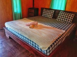 ein großes Bett mit einem hölzernen Fußbrett darauf in der Unterkunft Pondok rinjani bungalow tetebatu in Tetebatu