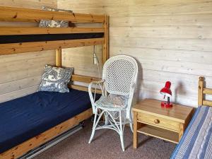 a bedroom with a bed and a chair and a table at Holiday home Kristinehamn VI in Kristinehamn
