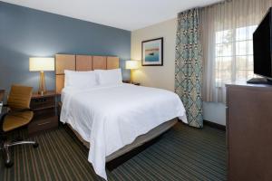 a hotel room with a large bed and a television at Candlewood Suites-West Springfield, an IHG Hotel in West Springfield
