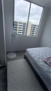 a bedroom with a bed and a window with a fan at Apto con vista panoramica al nevado del ruiz y del tolima in Ricaurte