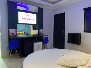 1 dormitorio con 1 cama blanca y TV en Refugius Motel en São Paulo