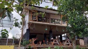 una casa con balcone e albero di Delta Island Camping Ground a Sumedang