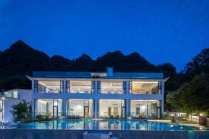una casa grande con piscina por la noche en Avatar Mountain Resort, en Zhangjiajie